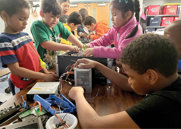 Young kids do a technology activity with wires and circuits.