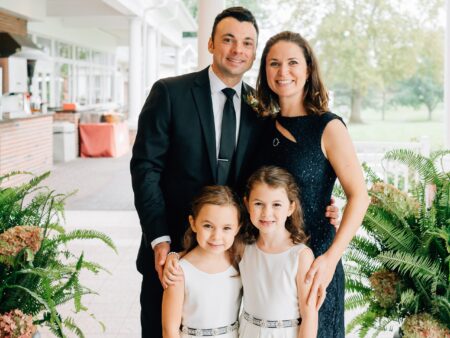 Charlie Ruff, his wife, and two children in formal attire.