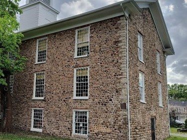 A cobblestone house with many windows.