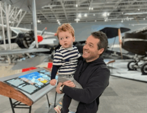 A man holds his young son in an aerospace museum