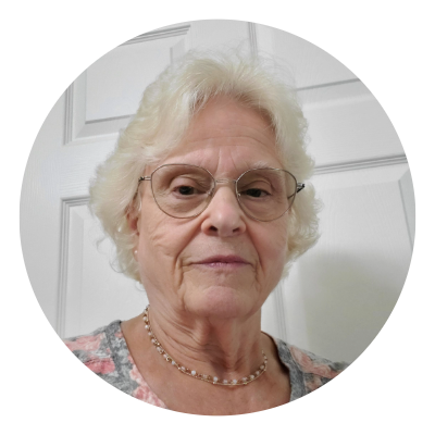 A woman in a floral shirt and a necklace.