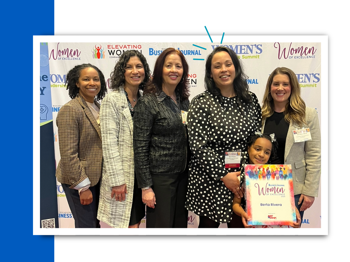 5 women and a child in front of a Women of Excellence banner