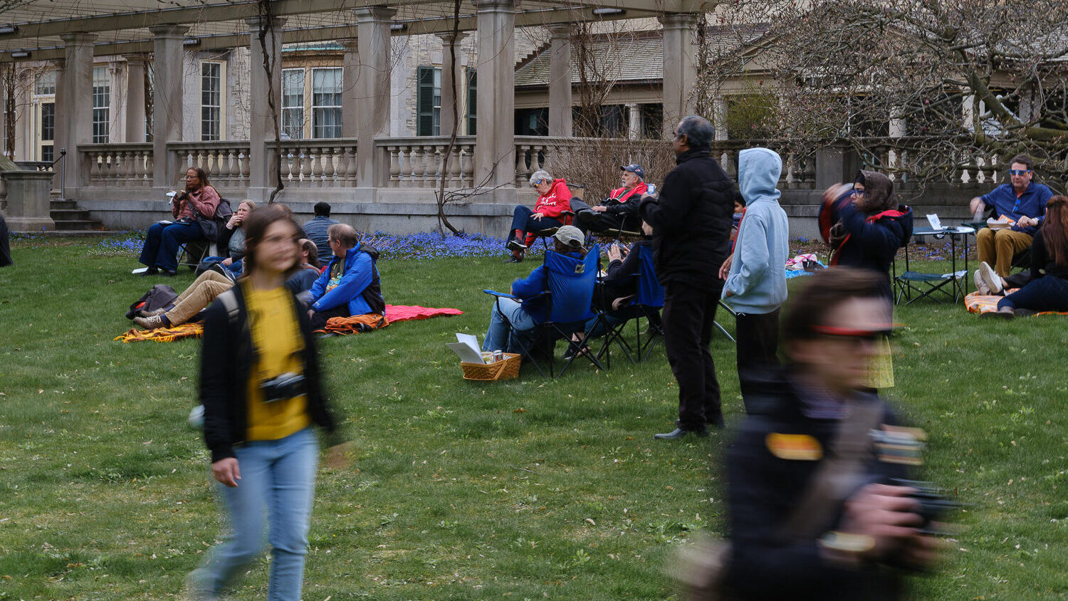 Blurred people hurry by the camera.