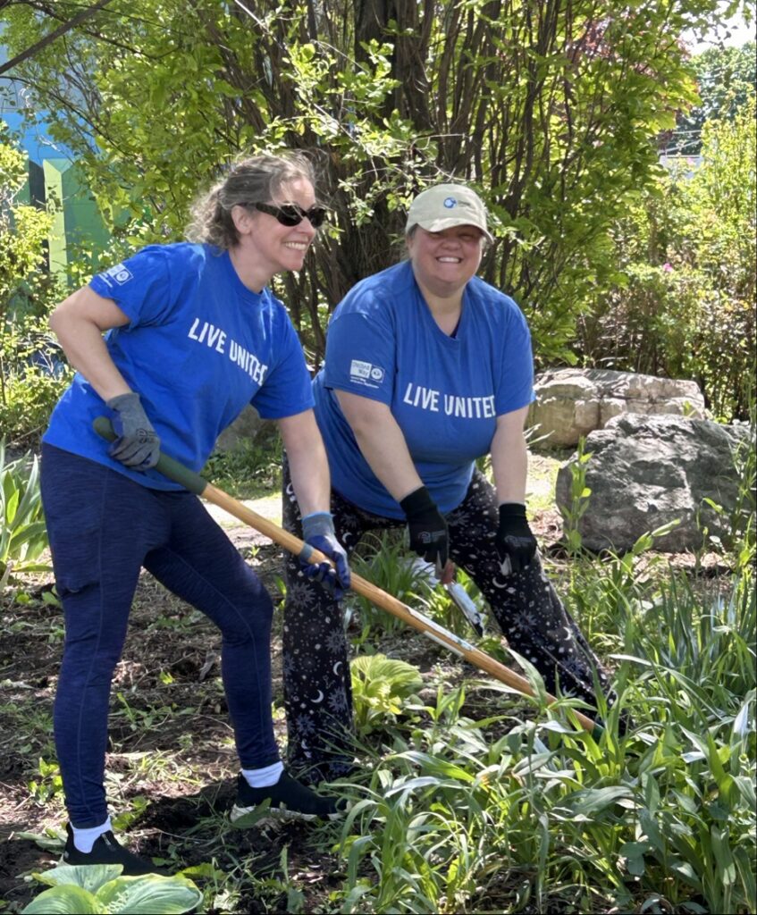 Kayleigh and Mary digging in the dirt at Day of Caring event