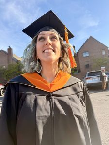 Alicia in a grad cap smiling